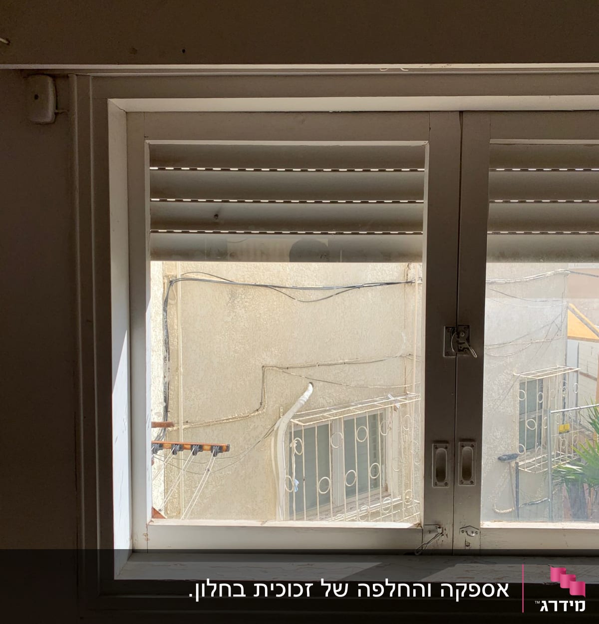 חלון זכוכית עם תריסים פתוחים חלקית